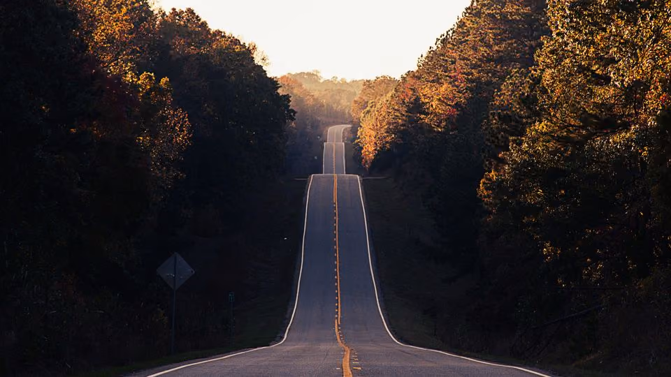 A lonely road going to mountains, representing the beginning of my website journey.